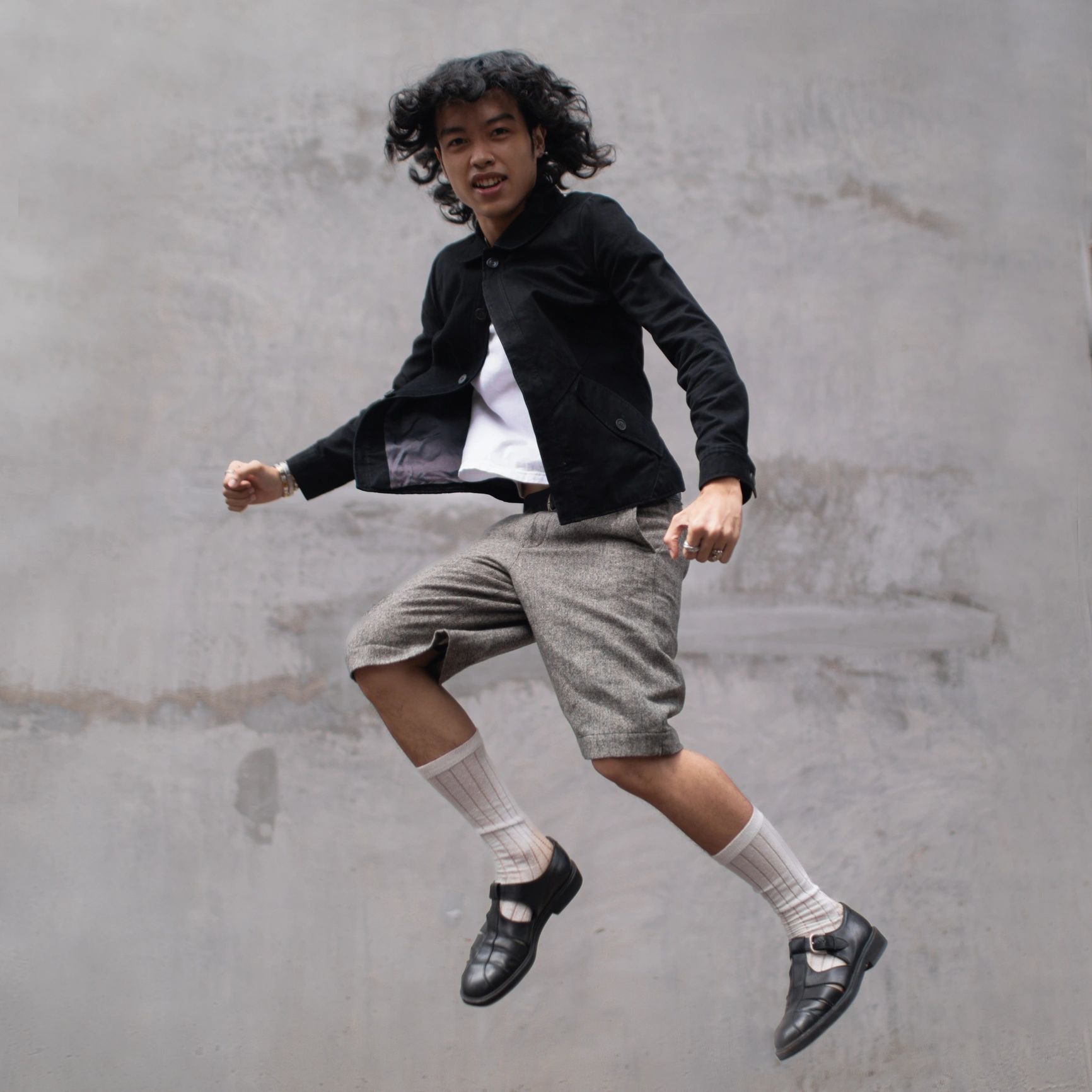 Streetwear model jumping in fashionable urban apparel